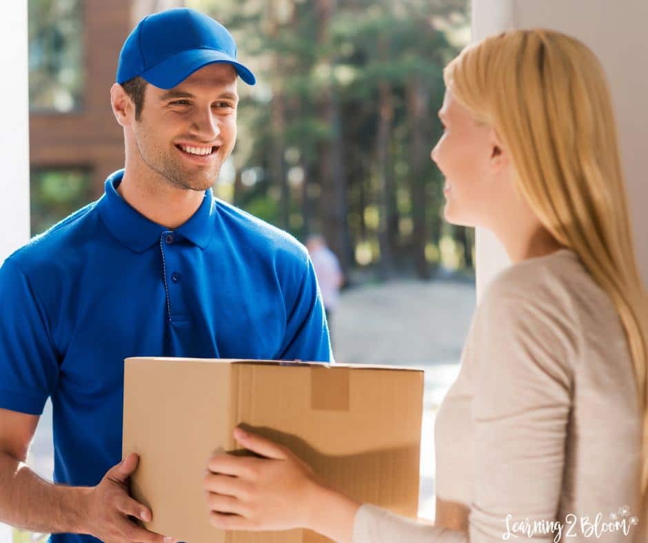 Delivery man handing box to woman in door way
