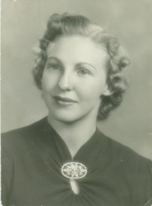Beautiful woman in 1930's with short curly hair and brooch