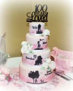 4 tiered pink and white cake. Topper says 100 Years loved. Mother, mom, Grandma, Great-Grandmother