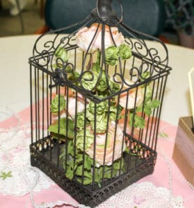 Birdhouse centerpiece with pink roses inside