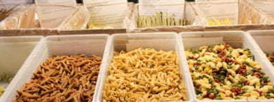 boxes filled with various types of Pasta with signs listing prices