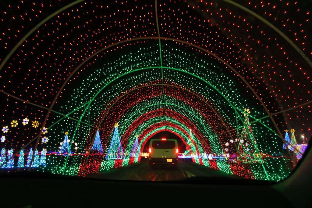 Tunnel of colored lights with Christmas trees, snowflakes and presents.