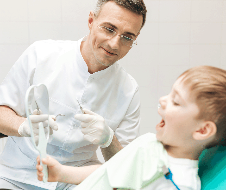 Child looking in mirror with dentist