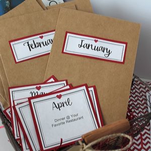 Basket with monthly envelopes and monthly cards listing that months gift.